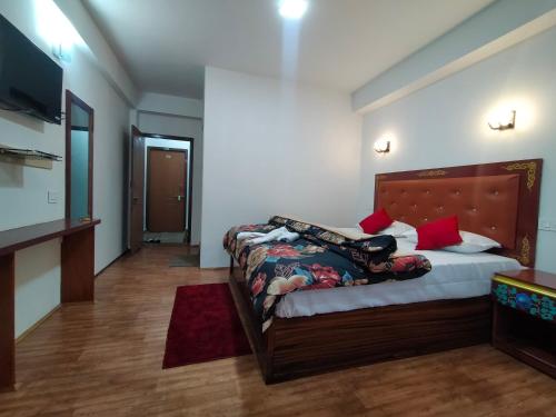 Sikkimese Inn في Ravangla: غرفة نوم فيها سرير وتلفزيون