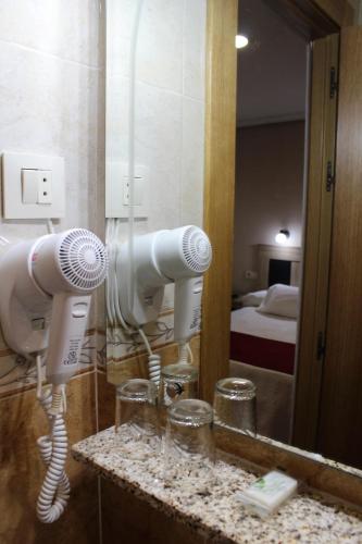 a bathroom with a blow dryer and a mirror at Hostal Madrid in Toledo