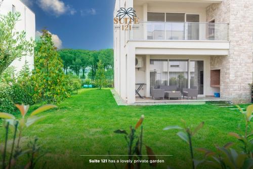 eine Ausstellung eines Hauses mit einem grünen Hof in der Unterkunft Suite 121 - San Pietro in Durrës