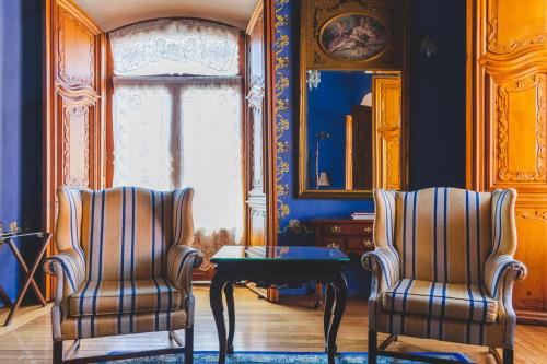 two chairs and a table in a room with blue walls at La Casa de la Marquesa in Querétaro