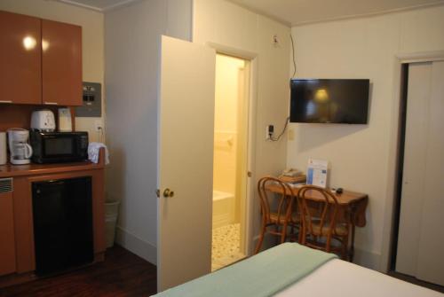 a room with a kitchen with a table and a bathroom at Lankford Hotel and Lodge in Ocean City