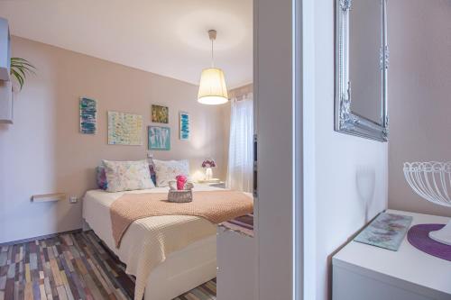 a small bedroom with a bed and a table at LunArta Apartments in Makarska