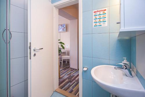 a bathroom with a sink and a mirror and a hallway at LunArta Apartments in Makarska
