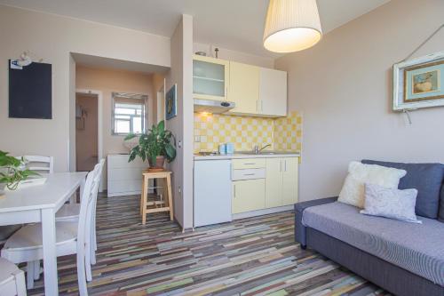 uma sala de estar com um sofá, uma mesa e uma cozinha em Apartments Prgomet em Makarska