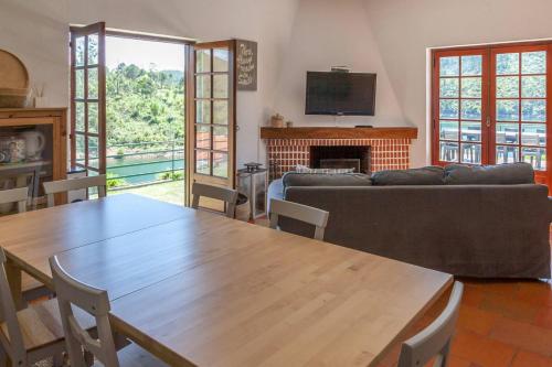 a living room with a table and a couch at Castelo de Bode - Lake House, A Casa do Avô in Levegada