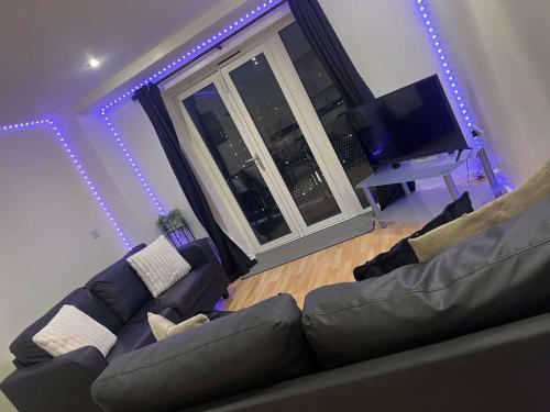a living room with a couch and a flat screen tv at 2 bedroom luxury apartment Birmingham city centre in Birmingham