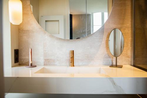 a bathroom with a sink and a mirror at Les Palissières in Mortagne-sur-Gironde