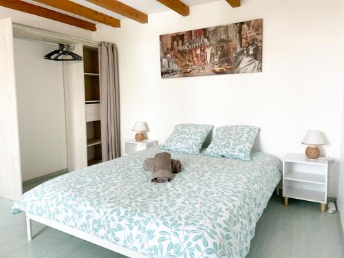 Un dormitorio con una cama con un osito de peluche. en Spacieux duplex central avec terrasse tropézienne en Salon-de-Provence