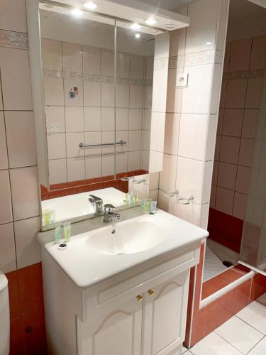une salle de bain avec un lavabo blanc et un miroir dans l'établissement Spacieux duplex central avec terrasse tropézienne, à Salon-de-Provence