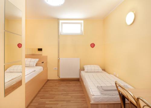 Habitación pequeña con 2 camas y ventana en Beg Rooms, en Maribor