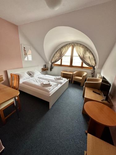 Cette chambre comprend un lit et une grande fenêtre. dans l'établissement Garni Hotel Gavurky, à Terchová