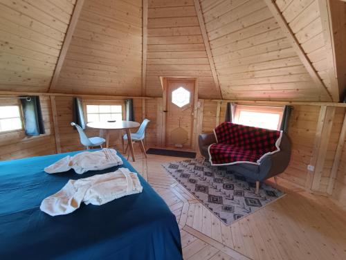 a room with a bed and a chair and a table at Les Cabanes du Grand Nord in Pradines