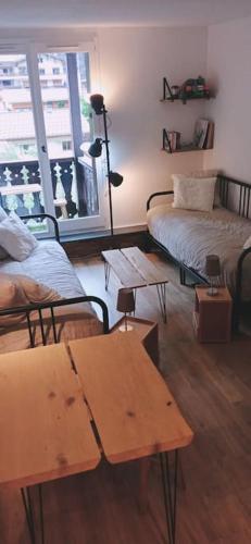 un salon avec deux lits et une table dans l'établissement Studio élégant à Chamonix, à Chamonix-Mont-Blanc