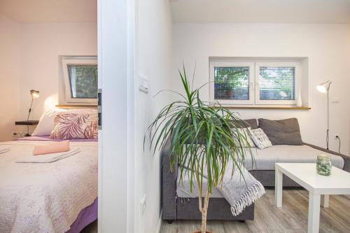 a bedroom with a bed and a potted plant at LunArta Apartments in Makarska