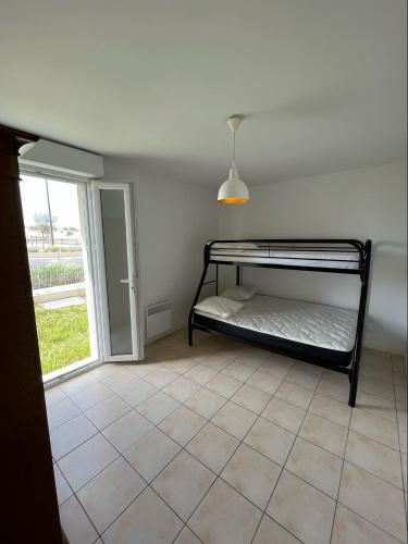 una camera con letto a castello e finestra di Appartement front de l'océan a Soulac-sur-Mer
