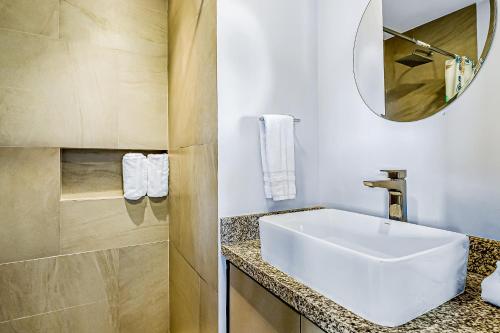W łazience znajduje się biała umywalka i lustro. w obiekcie Duva 903 w mieście Puerto Vallarta