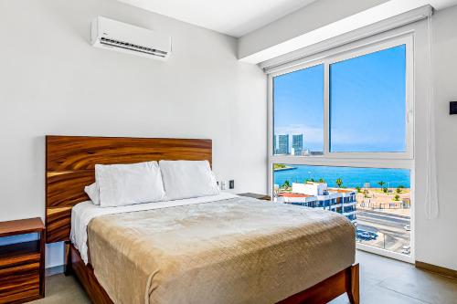 a bedroom with a bed with a view of the ocean at Duva 903 in Puerto Vallarta