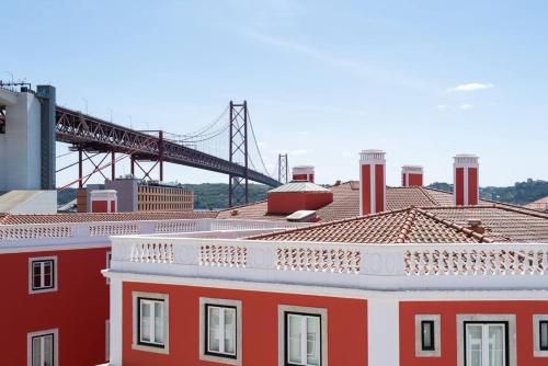 a red building with a bridge in the background at Amaro III - Stunning penthouse apartment in Alcantara in Lisbon