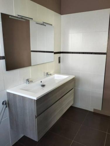 une salle de bain avec un lavabo blanc et un miroir dans l'établissement 20 people house swimming pool and beach, à Quimiac