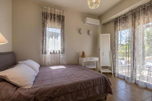 a bedroom with a bed and a large window at Villa Sunrise in Kiotari