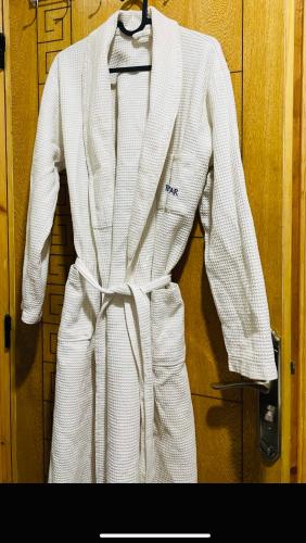 a white suit is hanging on a door at Appartement INES Saidia in Saidia 