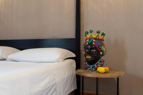 a statue of a head with a crown on a table next to a bed at Agriturismo Alle Riserve Cavagrande in Avola