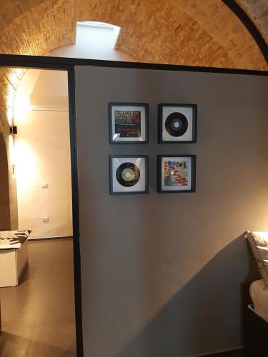 een kamer met vier ingelijste foto's aan een muur bij Urban79 in Bernalda