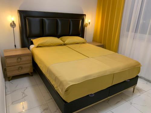 a bedroom with a large bed with a black headboard at Villa Scandinavia in Mostar