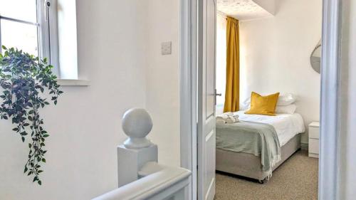 a bedroom with a bed with a yellow curtain at Spacious home near Newcastle City Centre in Hebburn-on-Tyne