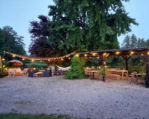 a group of tables and chairs under a pavilion with lights at Moulin de Monpoisson in Le Puy