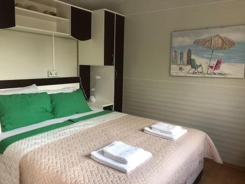 a bedroom with a large bed with towels on it at Tiny house & Glamping tent in Kotor