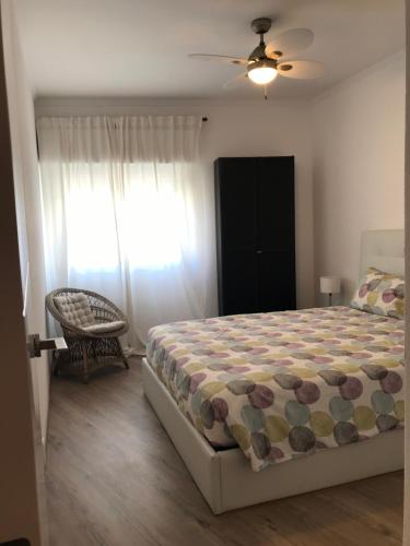 1 dormitorio con 1 cama, 1 silla y 1 ventana en New Casa Praia da Rocha, en Portimão