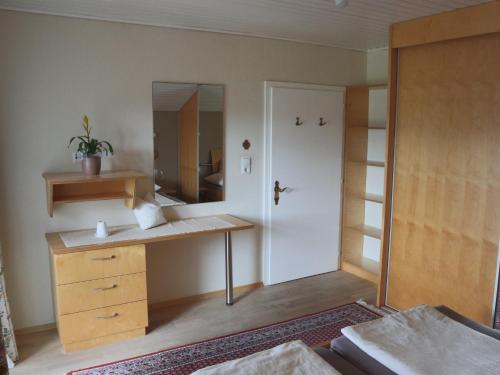 Schlafzimmer mit einem Schreibtisch und einem Spiegel in der Unterkunft Ferienwohnung am Rhein in Koblach