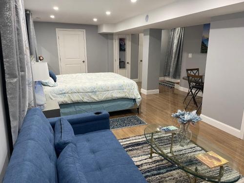 a living room with a blue couch and a bed at Brand New Luxury Rooms near downtown Boston in Boston
