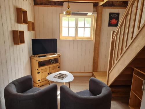 a living room with two chairs and a television at Le Domaine de la Claire Fontaine Gîtes -chambres d'hôtes in Montvalent