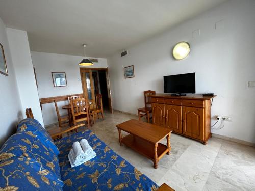 a living room with a blue couch and a tv at Gemelos 22-Fincas Benidorm in Benidorm