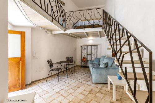 a living room with a staircase and a blue couch at Casa Mimina in Ischia