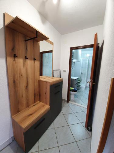 W łazience znajduje się drewniana umywalka i lustro. w obiekcie Apartman Mea w Rabacu