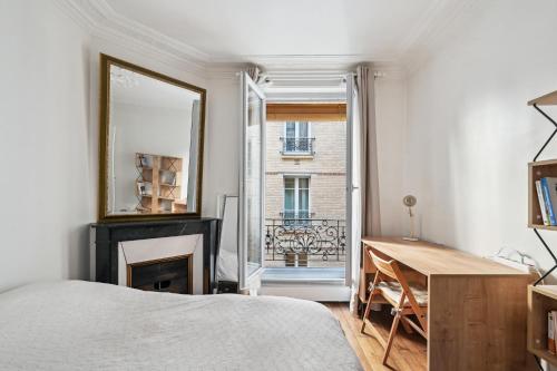 a bedroom with a bed and a mirror and a desk at Elégant appartement parisien pour 2 personnes à Paris by Weekome in Paris