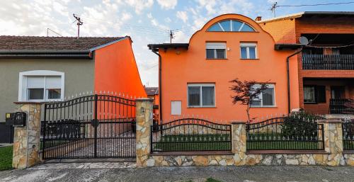 una casa naranja con una puerta delante de ella en Kuća za najam Villa Monika, en Osijek