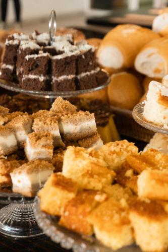 a bunch of different types of desserts on plates at Raf Hotel in Umuarama