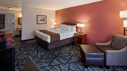 a hotel room with a bed and a chair at SureStay Plus Hotel by Best Western Auburn in Auburn