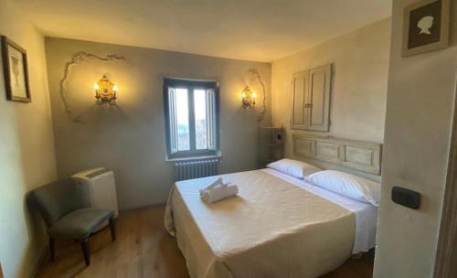 sypialnia z łóżkiem, krzesłem i oknem w obiekcie Residenza Buggiano Antica B&B - Charme Apartment in Tuscany w mieście Borgo a Buggiano