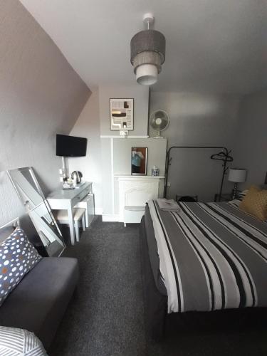 1 dormitorio con cama, escritorio y mesa en Caversham Lodge en Reading