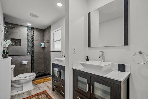 a bathroom with a sink and a toilet and a mirror at Enchanted Palms Villa in Boynton Beach