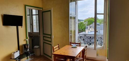 une salle à manger avec une table et une grande fenêtre dans l'établissement Le Continental, à Vittel
