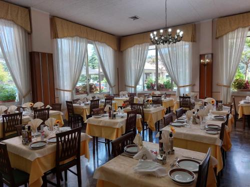 a dining room with tables and chairs and windows at Hotel Fleming in Fiuggi