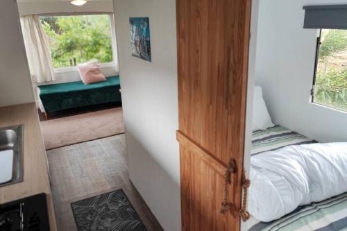 Habitación pequeña con cama y ventana en logement dans Mas mobile home en Saint-Laurent-dʼAigouze