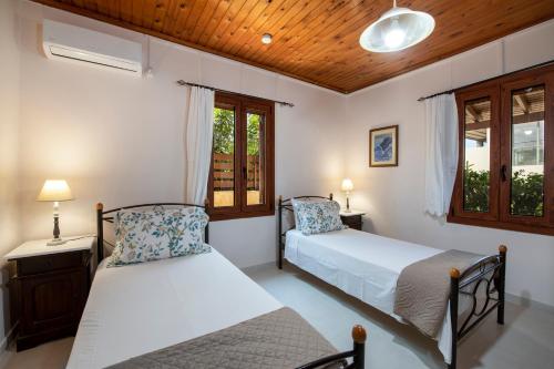 sypialnia z 2 łóżkami i oknem w obiekcie Elisavet's House w mieście Platanias