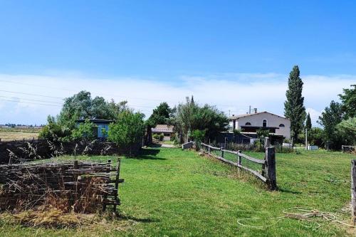a fence in a field next to a house at logement dans Mas mobile home in Saint-Laurent-dʼAigouze
